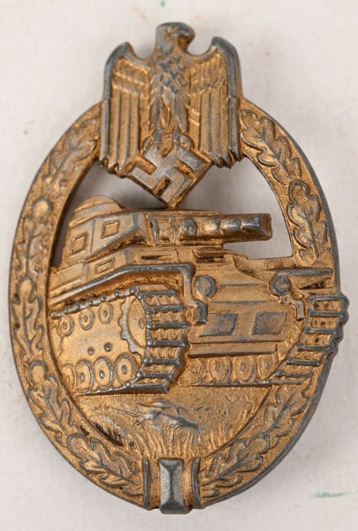 WWII NAZI PANZER ASSAULT BADGE IN BRONZE H. AURICH: German World War II Army Bronze Tank Assault Badge. The front shows a tank in the center with a German eagle clutching a swastika in his talons at the top. Both are surrounded by an oval oak leaf wrea