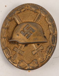 WWII NAZI GERMAN GOLD WOUND BADGE BY 127 WW2: 1939 pattern, die struck alloy construction, solid backed badge with a fire gilted finish features an embossed M35 pattern helmet with a high relief, canted, swastika to the center, superimposed over