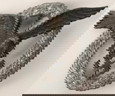 WWII NAZI GERMAN LUFTWAFFE PILOTS BADGE WW2: Late war production, die struck zinc construction, two piece badge is in the form of a vertically oval, wreath with a separate stylized, spread winged eagle in flight, clutching a canted swastika in i