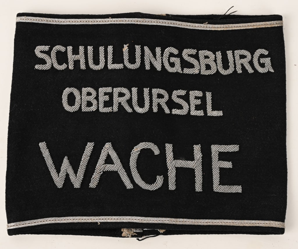 WWII NAZI SCHULUNGSBURG OBERURSEL WACHE ARMBAND: Very attractive SCHULUNGSBURG OBERURSEL WACHE Armband. This translates to TRAINING CAMP OBERURSEL WATCH. Bullion threads on a wide black wool armband with bullion officers stripes to the top