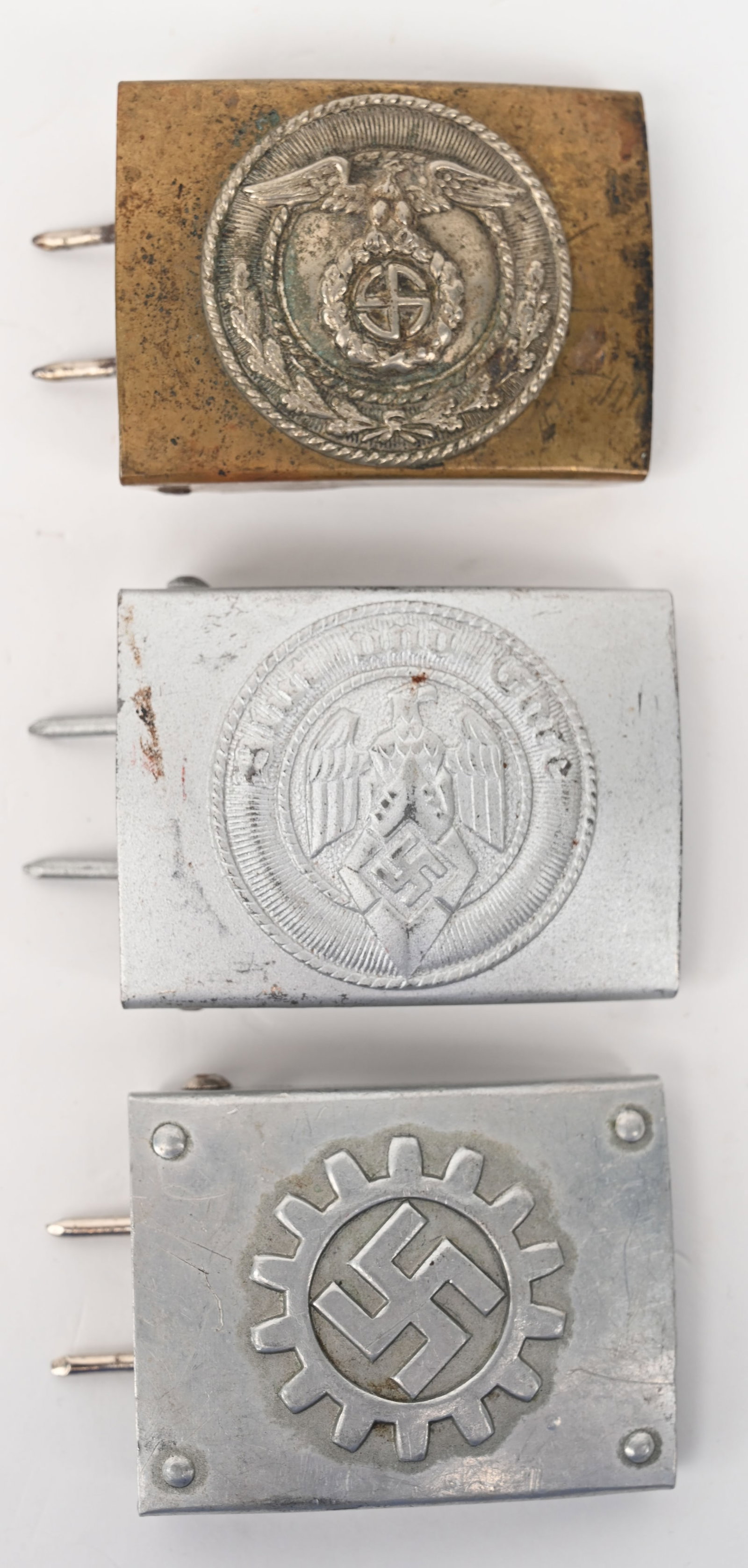 WWII NAZI GERMAN BELT BUCKLE LOT SA DAF HJ WW2: Lot of three WWII Nazi German Belt Buckles to include 1) SA EM/NCO'S BELT BUCKLE. Approximately 65mm x 50mm, slightly convex, stamped brass, one-piece construction buckle features, to its obverse, a p