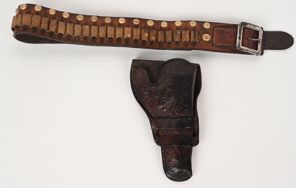 FULLY TOOLED 1890'S COLT HOLSTER / BELT: Double loop, fully floral hand tooled for a Colt 4 3/4" SAA. No skirt beyond second loop appears factory but could have been trimmed. Belt holds 38-41 caliber cartridges, decorated with brass studs. E