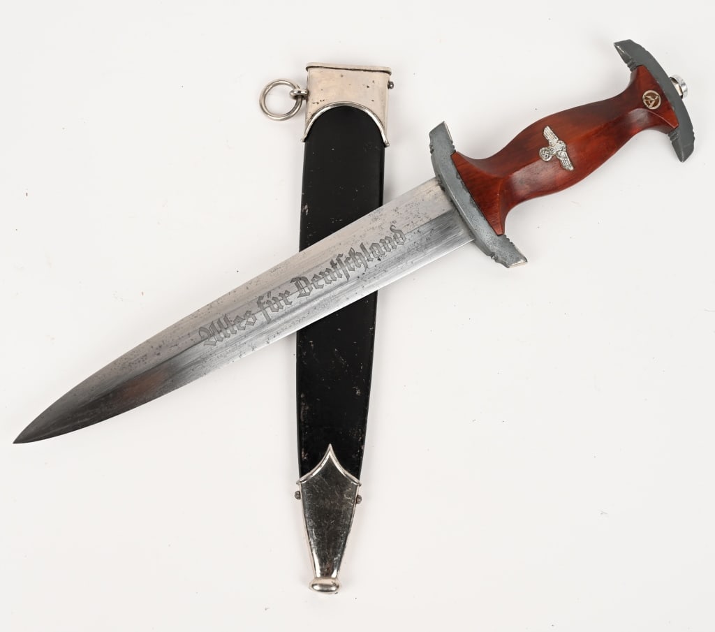 WWII NAZI GERMAN NSKK DAGGER BY PUMA w/ SCABBARD: NSKK dagger with a 22cm long double-edged drop-forged nickel-silver plated blade in its original scabbard. The dagger has a cast nickel-silver plated pommel and tang nut. Its contoured wooden grip has