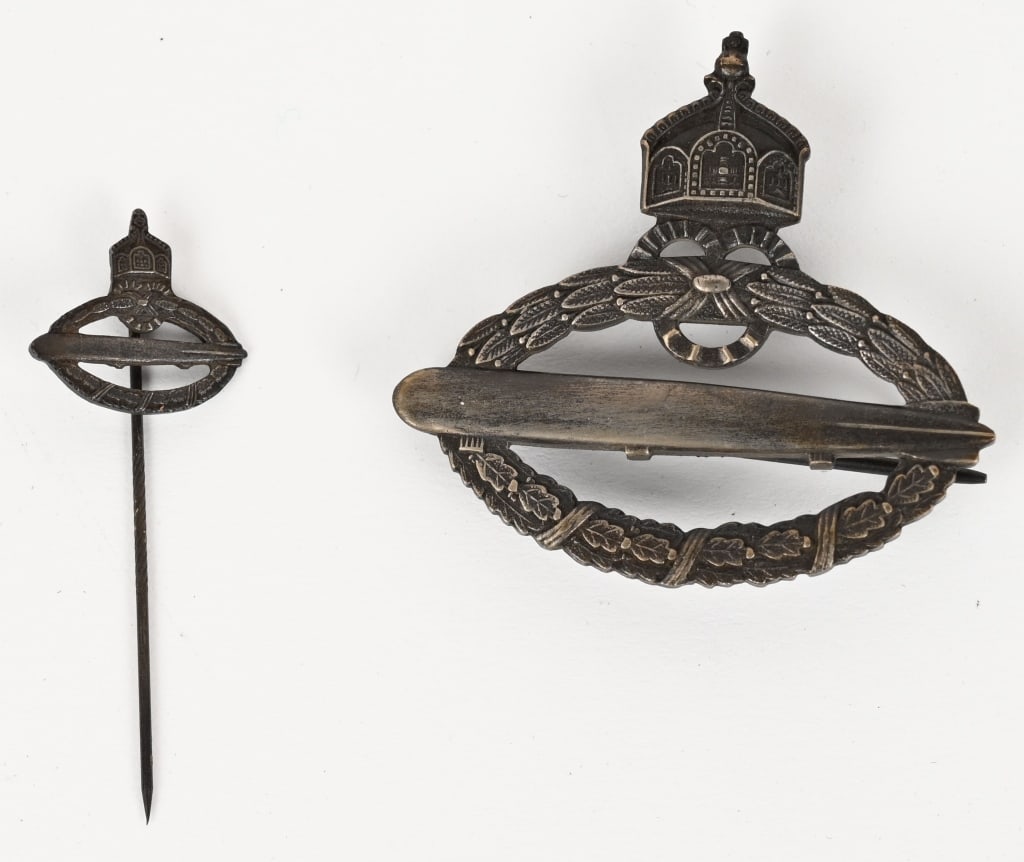 WW1 IMPERIAL GERMAN NAVY ZEPPELIN BADGE WWI: Imperial German Navy Zeppelin Badge. Darkened silvered open oak leaf wreath holding a Zeppelin in flight. Three open partial circles at the top of the wreath provide a base for a Hohenzollern crown. A