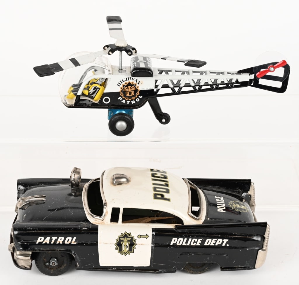 2- JAPAN TIN FRICTION POLICE TOYS: Includes Police patrol car missing hubcaps and Police Helicopter. Both working. Largest 8" Excellent