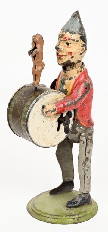 GUNTHERMANN CLOWN DRUMMER w/ POODLE: German hand painted tin windup Clown Drummer with performing Poodle. The clown drums, with plink plink music, nods his head and Poodle twirls. Original paint. Windup works. 8 1/2" Very Good- Excellent