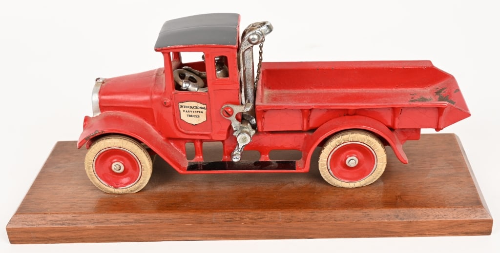 ARCADE CAST IRON INTERNATIONAL RED BABY AWARD: Unique Arcade cast iron International Red Baby Award. This toy was mounted on a wood base and presented to Perry E Dewitt for being Salesman of the Year at a local International Harvester Dealer in th
