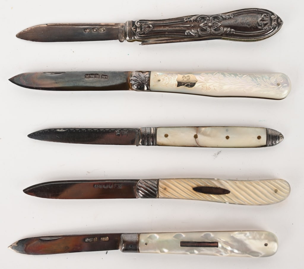FIVE ASSORTED PEARL & SILVER BLADE FRUIT KNIVES: This assortment contains 5 folding fruit knives that feature mother-of pearl handles and sterling silver blades from various manufacturers with proof marks. The knife itself is also known as a "slippi