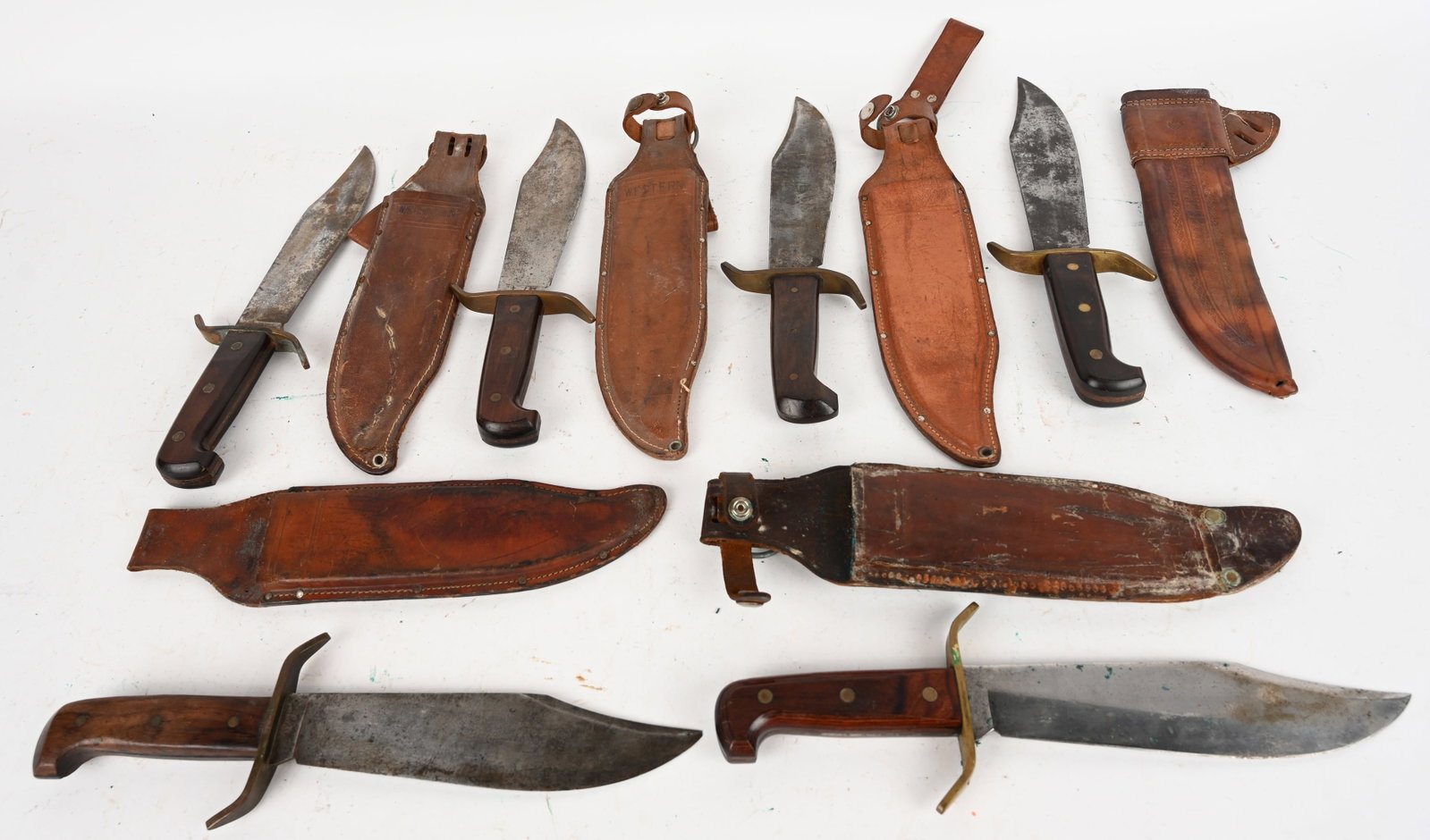 LOT OF 6 WESTERN BOWIE KNIVES W// SHEATHS: This is a lot of 6 w49 Western Bowie knives with sheaths. Blade: 9 3/8". OAL: 14 1/8". Condition: Fair. Blades are stained but retina their edge. Handles are in good condition. All are well put togeth
