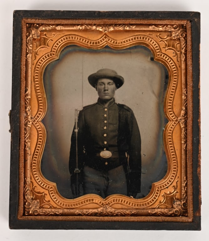 CIVIL WAR CONFEDERATE ARMED TINTYPE GEORGIA PLATE: Very attractive, well armed Civil War Tintype measuring 3 3/4 X 31/4 inches showing a well armed Confederate Soldier wearing a Kepi, 9 button Frock Coat, Georgia State Waist Belt and holding a rifle a
