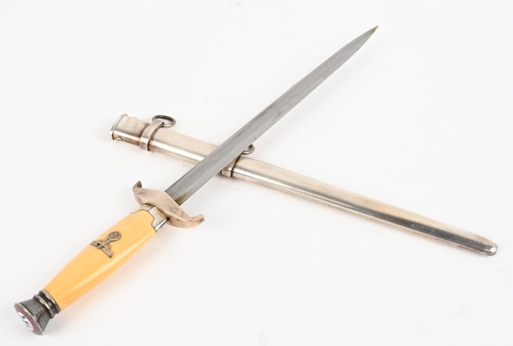 WWII NAZI GERMAN UNKNOWN DAGGER PROTOTYPE NSDAP: WWII Nazi German possibly a Prototype Dagger measuring 15 1/2 inches in total length with a celluloid grip with a political eagle to its center. To the top of the pommel cap is an enameled NSDAP insig