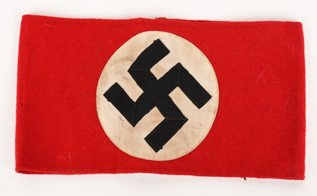 WWII NAZI GERMAN NSDAP MEMBER'S ARMBAND WW2: A red wool armband, upon which is sewn an approximately 9cm diameter white disk, with a black multi piece mobile swastika. Still retains the paper RZM Tag. Excellent. Probably one of the most recogniz