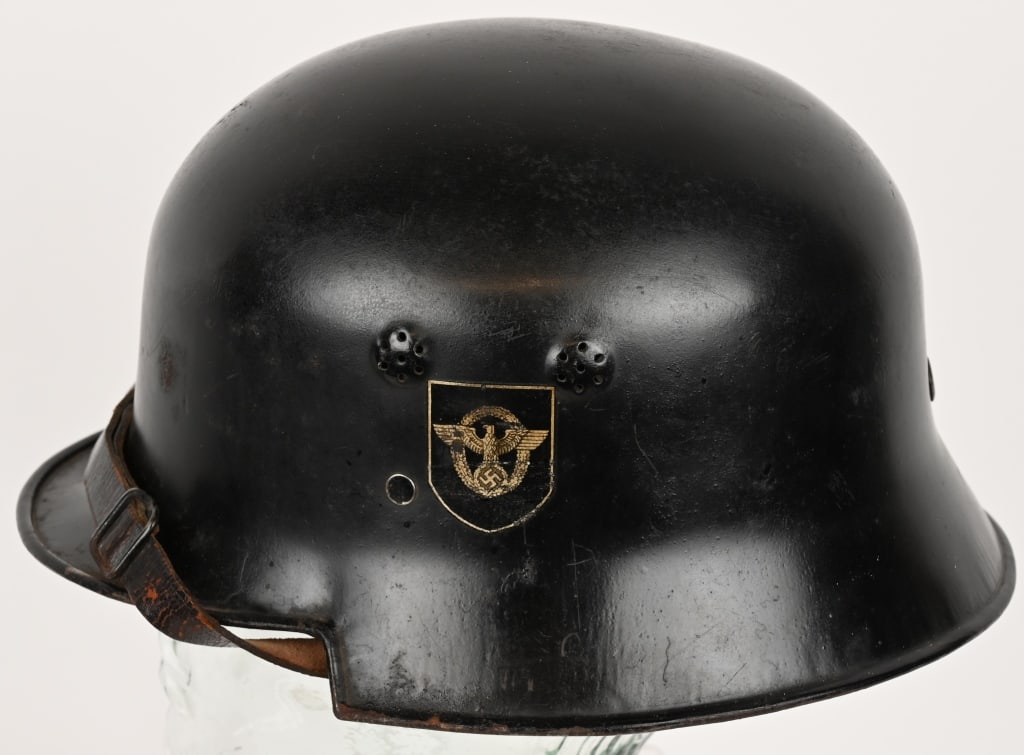 WWII NAZI M34 FEUERSCHUTZPOLIZEI POLICE HELMET WW2: The stamped, sheet steel construction helmet retains most of its original black paint. The left side of the helmet has a silver bordered, black based, police decal with the second pattern, silver, wre