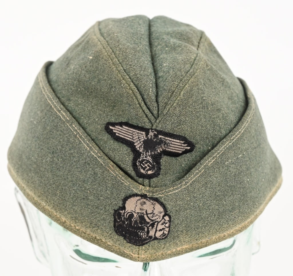 WWII NAZI GERMAN WAFFEN SS OVERSEAS CAP WW2: Field-gray wool/rayon blend construction M40 overseas cap with fold down side and back panels that slope gently downwards to the front center. The front center of the cap has a second pattern, (circa
