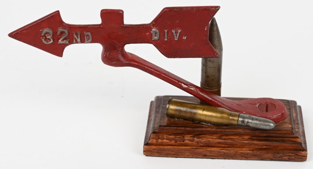 WWII US ARMY 32ND INFANTRY DIVISION DESK ORNAMENT: Attractive WWII 32nd Division Desk Ornament measuring 8 1/4 X 4 1/4 inches with the red arrow device being made of aluminum and having a .50 BMG and a Krag Rifle Round mounted on a wood base. Excellen