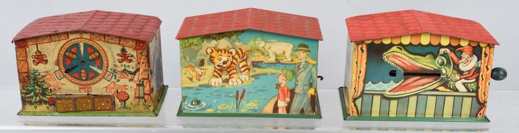 3-HOUSE tin MECHANICAL BANKS, GERMANY: Nice lot includes a Punch and Judy with Alligator bank, A Zoo bank, and a Hansel & Gretel bank. The Zoo bank has some fading, The Hansel and Gretel bank has wear and an enlarged slot, and the Punch