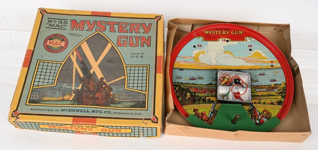 MAC 1920'S TIN MYSTERY GUN SHOOTING TOY w/ BOX: Nice all tin toy made by McDowell Toy Manufacturing Pittsburgh PA. Has 4 tin airplanes, ball bearings and pull string. Includes scarce original graphic box. 13" diameter. Excellent