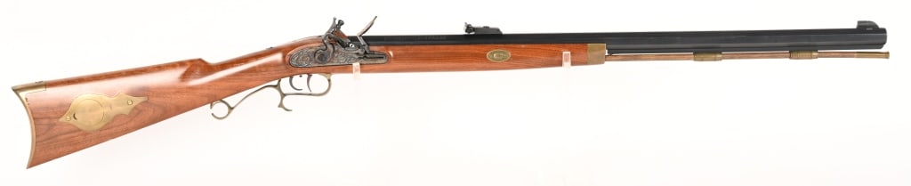 THOMPSON CENTER ARMS FLINTLOCK 50 CAL: SERIAL NUMBER: 59781 BARREL: 29" CALIBER: 50 BP MANUFACTURED: 1990's Blue finish barrel with rifle sights. Case color lock with brass trigger guard and patch box, butt plate. CONDITION: Metal is 85% w