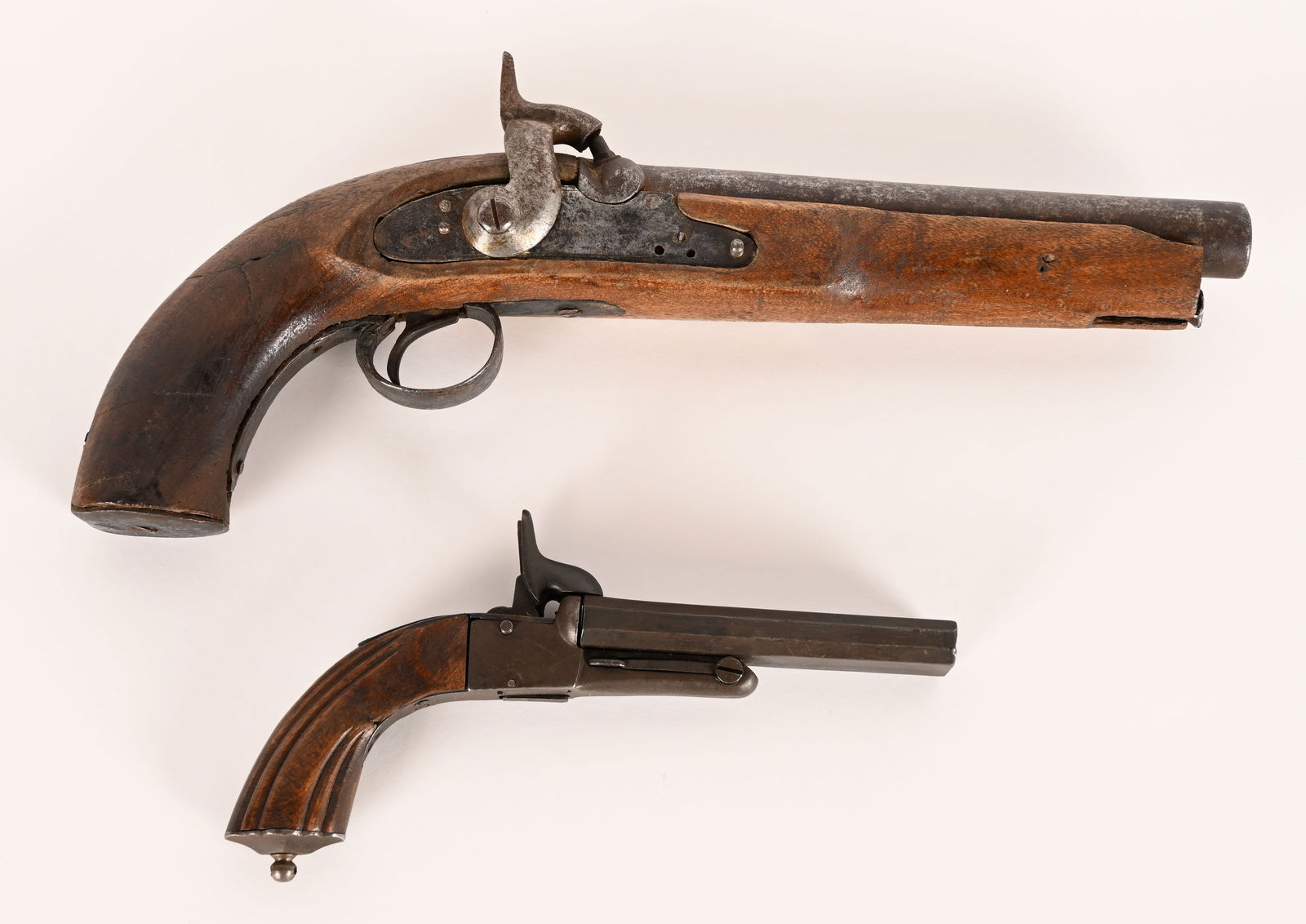 2- ANTIQUE PISTOLS , PERCUSSION & PINFIRE: Lot includes : 1. Belgian double barrel pinfire pistol. 4 1/2" barrel, about .9mm. Complete, works with dark patina. Good, 2. Early French single shot pistol. 8 1/4" barrel about .75 caliber. Arsenal