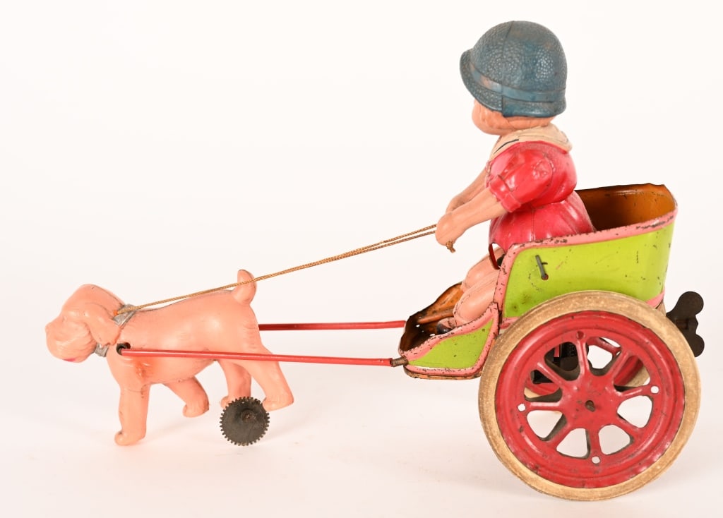 PRE-WAR JAPAN CELLULOID WINDUP GIRL IN DOG SULKY: Pre-War Japan celluloid and tin Girl in Dog Sulky. Oversized toy. All original in wonderful condition. Windup works. 10" Excellent