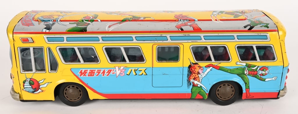 NOMURA TIN FRICTION KAMEN RIDER BUS: Japan tin friction Kamen Rider Bus. Very large toy with great graphics and colors. Has a few spots of loss. Friction works. A very hard to find Japanese Character Toy. 15 1/2" Very Good-Excellent