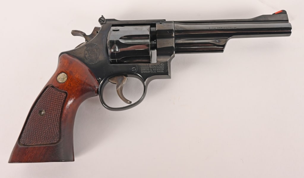 SMITH & WESSON MODEL 27-2 357 MAGNUM 6": SERIAL NUMBER: N694488 BARREL: 6" CALIBER: .357 MAGNUM MANUFACTURED: 1976 This fully optioned Model 27-2 is equipped with a 6" barrel, original bright blue finish, red ramp front sight, white outline