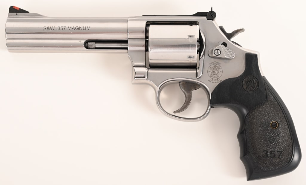 SMITH & WESSON MODEL 686-5: SERIAL NUMBER: DUE0747. BARREL: 4". CALIBER: .357 Magnum. MANUFACTURED: 2005. This seven-shot Model 686-5 is equipped with a 4" barrel, stainless steel construction and laminated S&W factory grips. CO