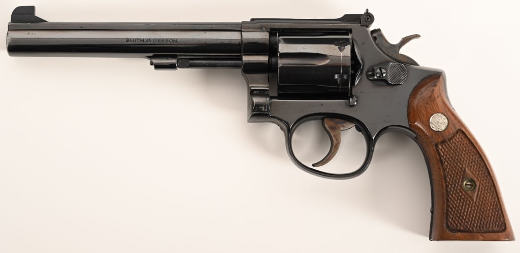 SMITH & WESSON MODEL 17 NO DASH K22: SERIAL NUMBER: K412905. BARREL: 6". CALIBER: .22 LR. MANUFACTURED: 1960. Built on the four screw K-frame this fine K-22 Masterpiece is equipped with a 6" barrel, original bright blue finish and