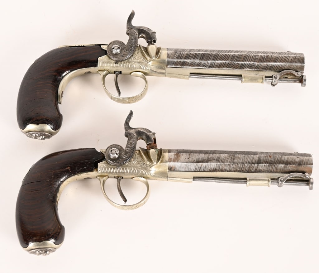 PAIR SHARPE LONDON PERCUSSION PISTOLS: SERIAL NUMBER: N/A, BARREL: 4 1/4" CALIBER: .44 , MFG: 1850-1865. Pair of matching Sharpe London percussion pistols. Silver mounted, engraved, with octagon damascus barrels and walnut grip. Has