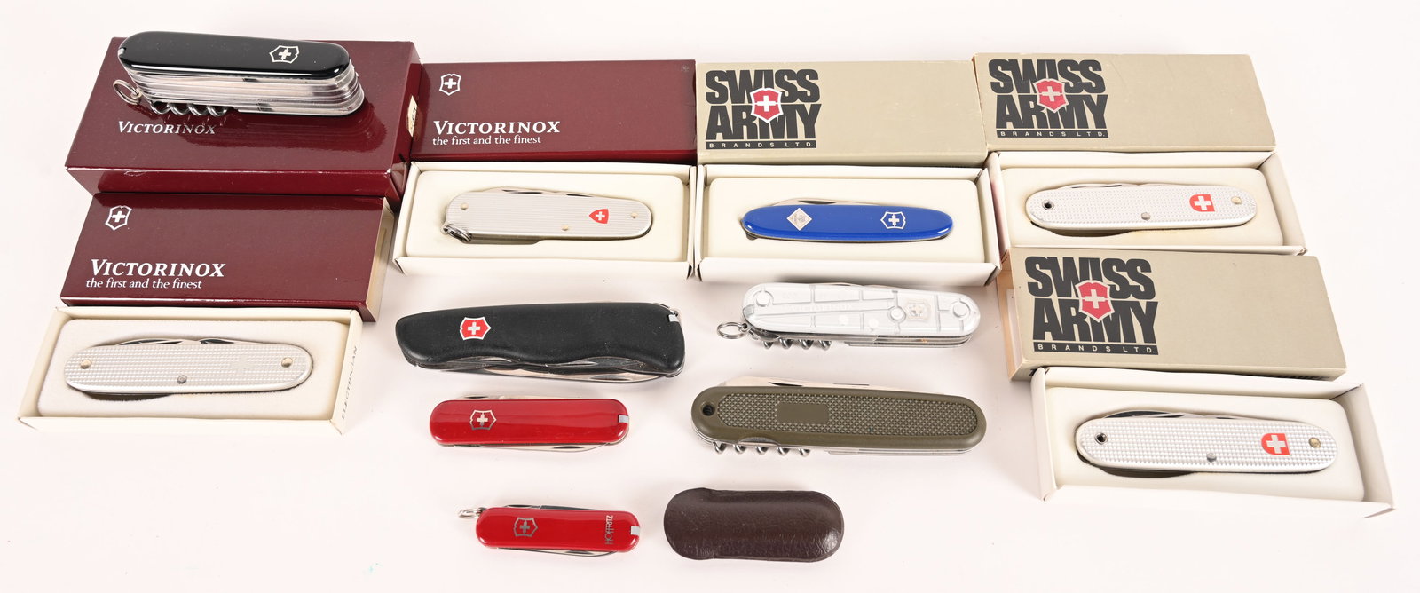A HANDSOME LOT OF 12 VICTORINOX POCKET KNIVES: This lot contains: (1) The Champion of the Swiss Army Officer's knives, 24 functions (2) Soldier Models (1) Cadet Model (1) Pocket Pal Cub Scout model (1) Electrician Model (1) Silver climber (1) Clas