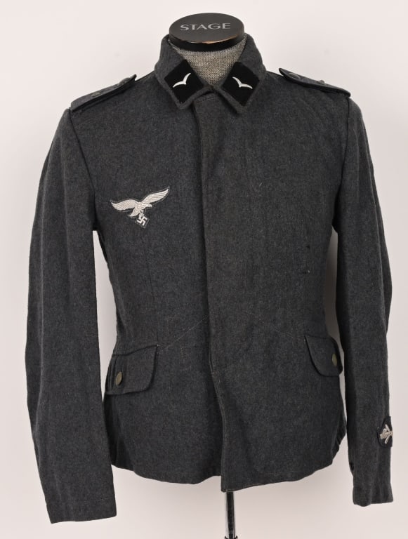 WWII NAZI GERMAN LUFTWAFFE PIONEER FLIGHT BLOUSE: Second pattern, (Circa May 1940-May 1945), EM/NCO’s flight blouse with external hip pockets. The Luftwaffe blue/gray, wool/rayon blend construction flight blouse features a vertical, five button