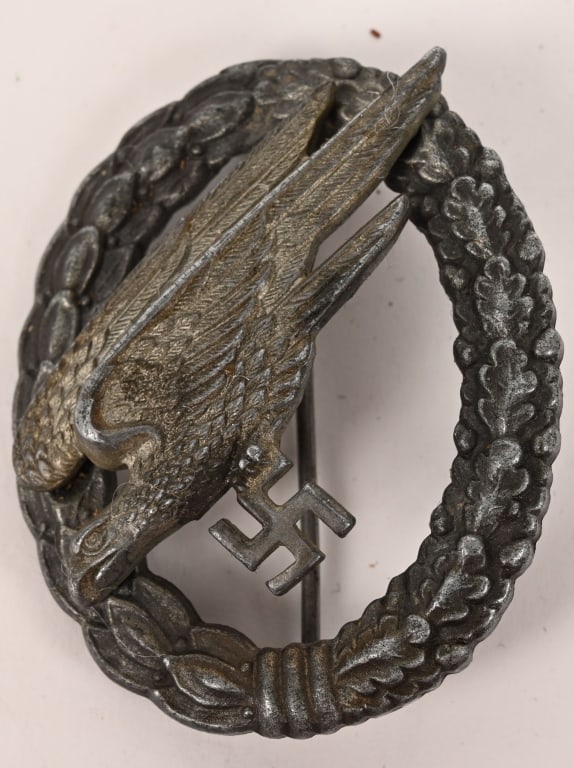 WWII NAZI GERMAN LUFTWAFFE PARATROOPER BADGE WW2: Two piece, die struck zinc award features a stylized, "diving", eagle clutching a swastika in its talons, encompassed by a vertically oval wreath. The wreath features embossed laurel leaves to the rig
