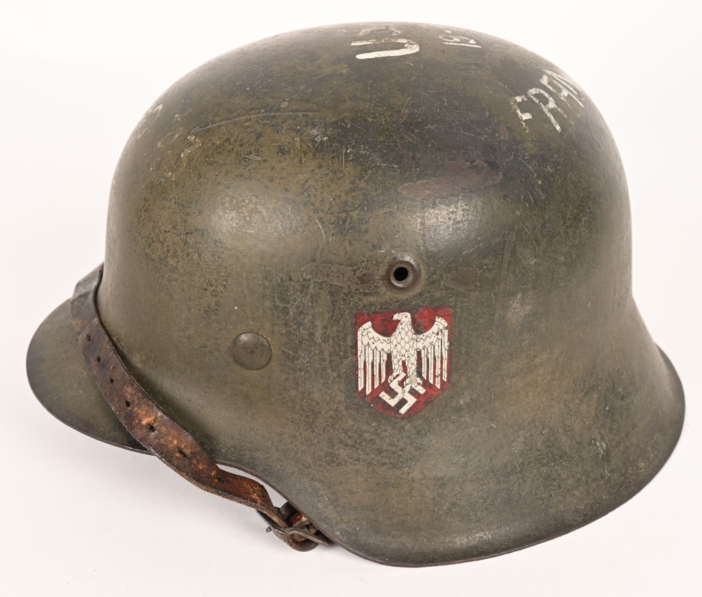 WWII NAZI GERMAN SINGLE DECAL HELMET W/ TRENCH ART: The stamped, sheet steel construction helmet retains most of its factory applied field-gray paint. The left side of the helmet has an Wehrmacht eagle shield decal featuring a eagle with down-swept win