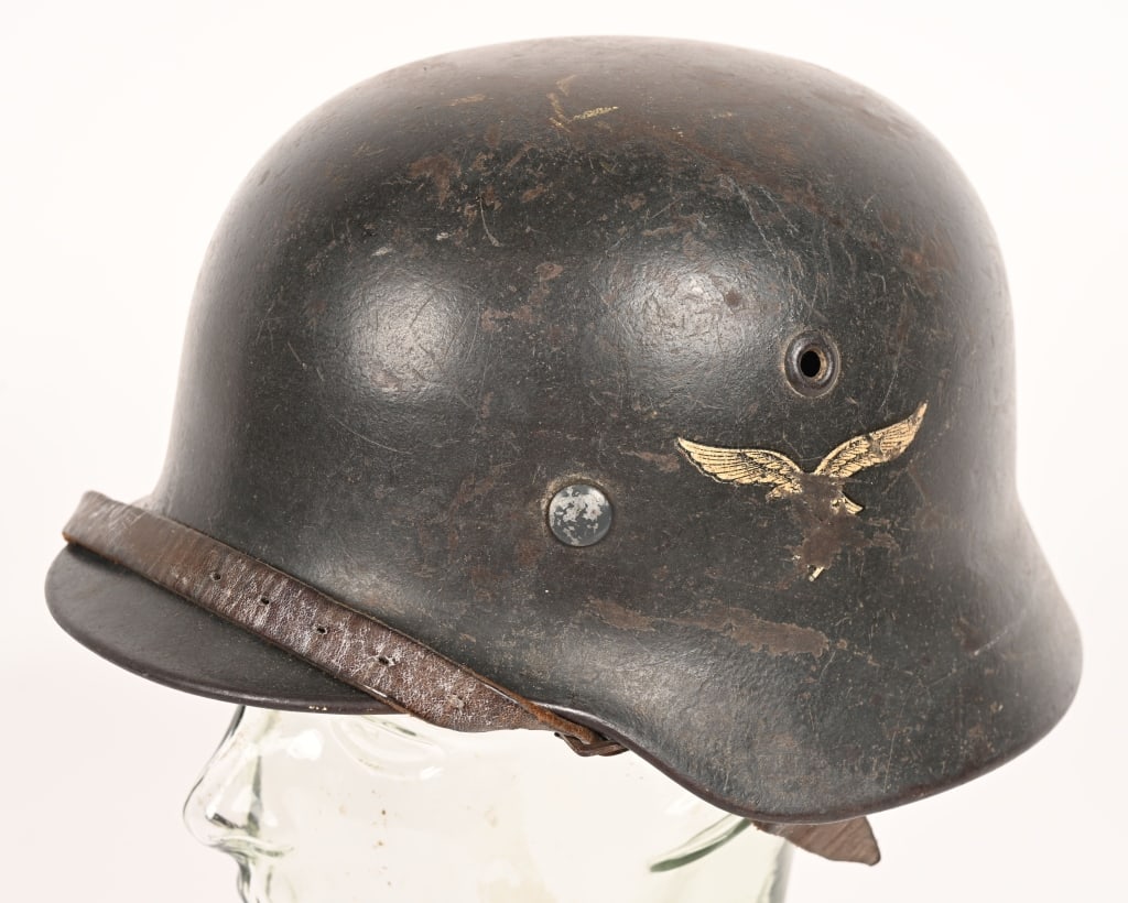 WWII NAZI GERMAN LUFTWAFFE M40 SINGLE DECAL HELMET: The stamped, sheet steel construction helmet retains most of its original rough textured paint. The left side of the helmet has a second pattern, (Circa 1936/1937-1945), black detailed,