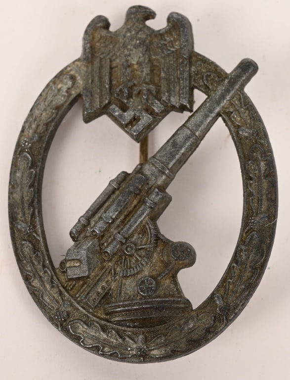 WWII NAZI GERMAN ARMY FLAK ARTILLERY BADGE WW2: Die struck, solid backed, alloy construction badge with a silver wash, features an embossed, vertically oval, oak-leaf wreath with a Wehrmacht style eagle, with down-swept wings, clutching a canted sw
