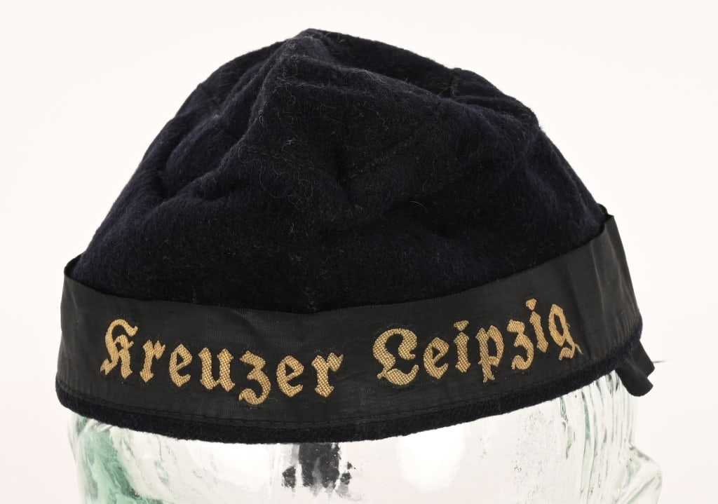 WWII NAZI GERMAN KRIEGSMARINE KREUZER LEIPZIG CAP: Nice quality, deep navy blue wool/rayon blend construction overseas cap features a cap tally that reads Kreuzer Leipzig in gothic script. The interior of the cap is fully lined in light weight r