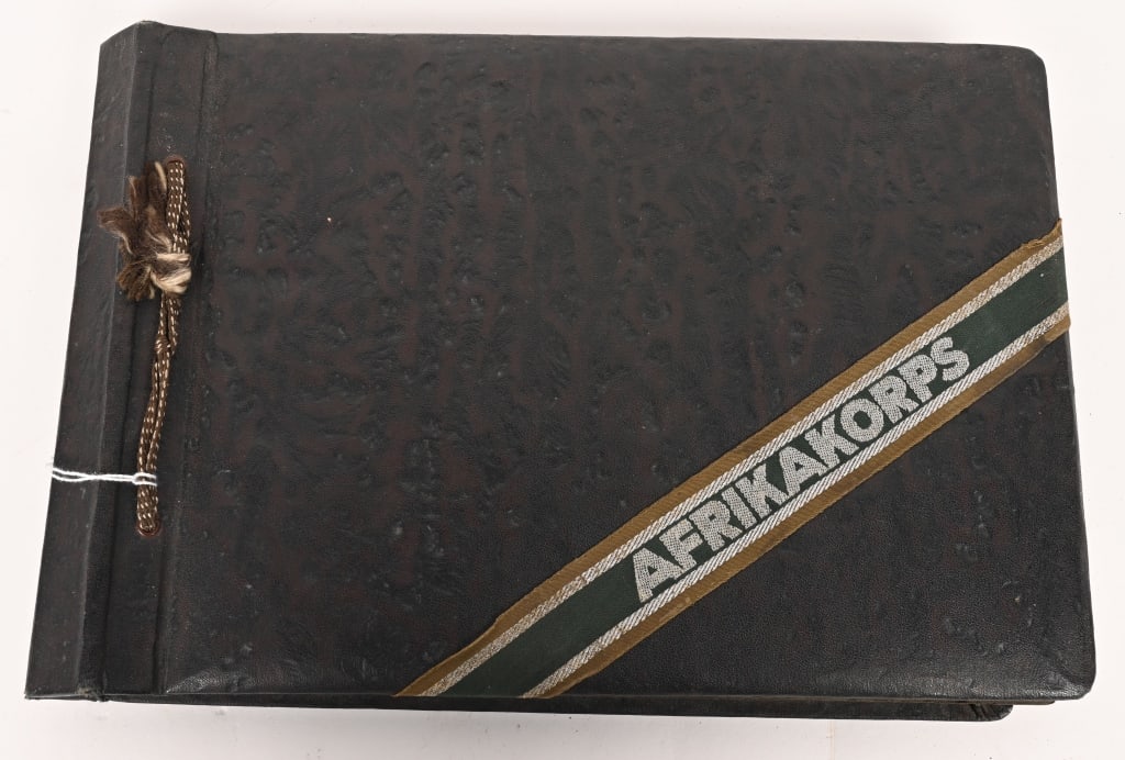 WWII NAZI GERMAN AFRIKAKORPS PHOTO ALBUM W INSGNIA: Very attractive WWII Nazi German Afrikskorps Photo Album. To the front cover is an original applies AFRIKAKORPS Cufftitle that is uncut. To the interior are 144 images of the Wehrmacht in the Theater