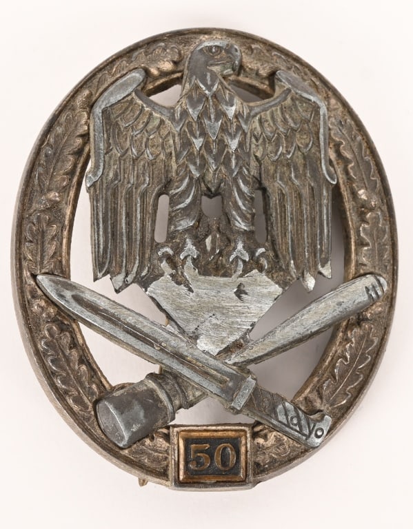 WWII NAZI 50 GENERAL ASSAULT BADGE BY JUNCKER WW2: Large, two piece, highly convexed, die struck zinc alloy construction badge with a burnished blued wash and a nickel/silver plated finish features a vertically oval, embossed, oak-leaf wreath