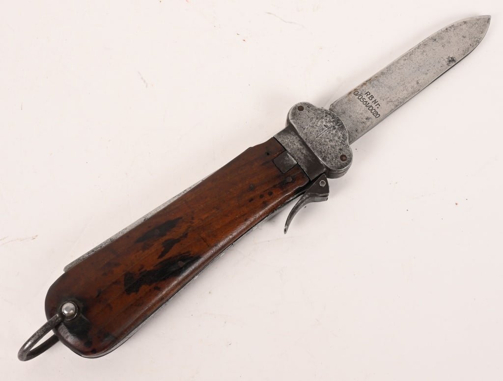 WWII NAZI GERMAN FALLSCHIRMJÄGER GRAVITY KNIFE WW2: A Luftwaffe paratrooper knife using a sliding steel blade inside a metal grip fitted with walnut, the grain running through vertically, grip plates. The blade is a relatively blunt spear-point with a