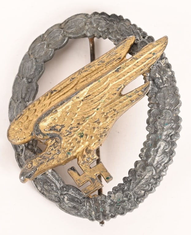 WWII NAZI GERMAN LUFTWAFFE PARATROOPER BADGE B&NL: Mid-war production, two piece, die struck zinc award with silver and gilt washed finishes features a stylized "diving" eagle clutching a swastika in its talons, encompassed by a vertically oval wreath