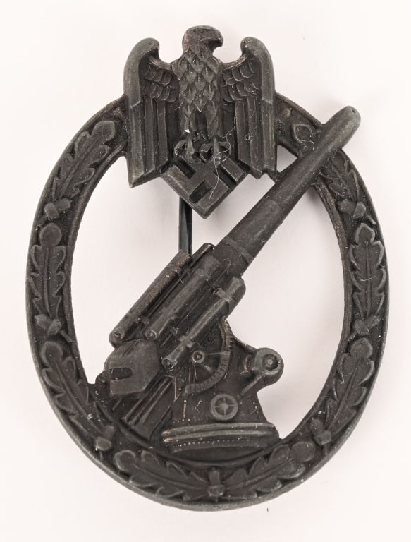 WWII NAZI GERMAN ARMY FLAK ARTILLERY BADGE JUNCKER: (Flakkampfabzeichen des Heeres). Constructed of silvered zink, the obverse consisting of an oval oak leaf wreath, topped by a Heer-style German national eagle clutching a mobile swastika, around a cen