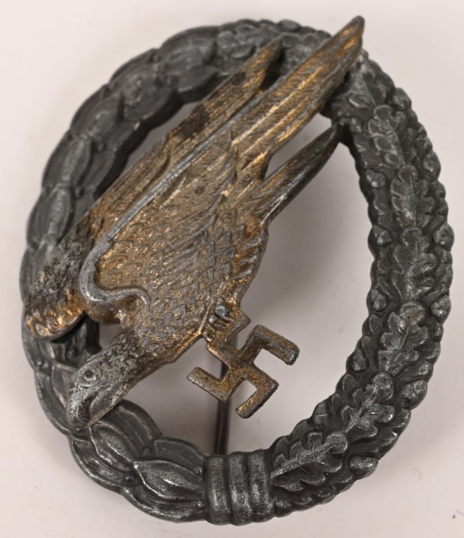 WWII NAZI GERMAN LUFTWAFFE PARATROOPER BADGE WW2: Two piece, die struck zinc award features a stylized, "diving", eagle clutching a swastika in its talons, encompassed by a vertically oval wreath. The wreath features embossed laurel leaves to the rig