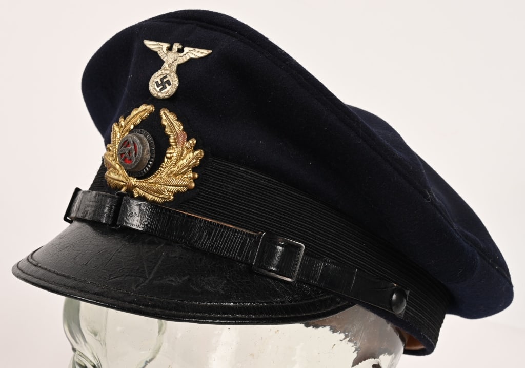 WWII NAZI GERMAN SA MARINE VISOR CAP OR HAT WW2: (Marine-Sturmabteilung Schirmmütze). A Marine-Sturmabteilung (Marine-SA) visor cap, constructed of a dark navy-blue wool. The cap features reinforced side walls, fully lined on the exterior with