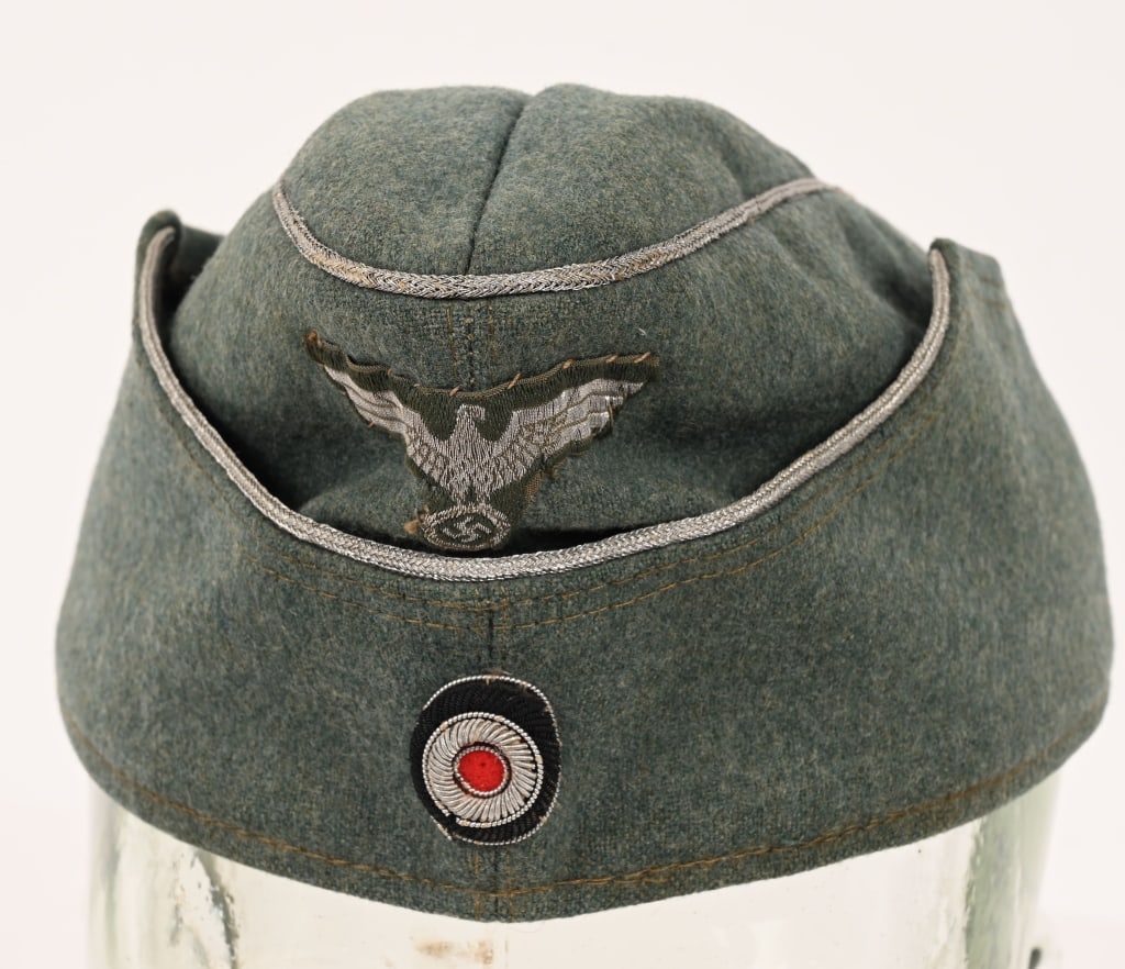 WWII NAZI GERMAN HEER OFFICER'S M38 OVERSEAS CAP: Nice quality, M38 pattern, field-gray wool and rayon blend construction cap with a subtly ribbed gaberdine weave. The cap features fold down side and back panels with scalloped slopes to the forward s