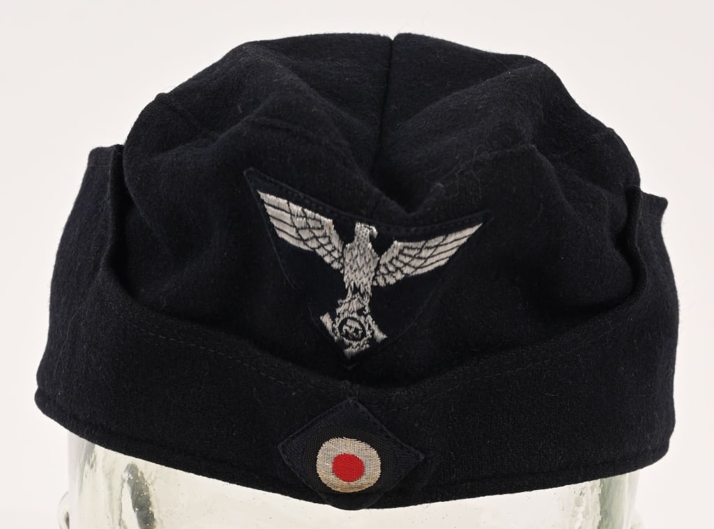 WWII NAZI GERMAN TENO OVERSEAS CAP WW2: Dark navy blue wool/rayon blend cap, with fold down scalloped sides. Sides have stitched in hooks to slip through metal grommets on cap body sides. Machine woven TeNo insignia in silver/aluminum threa