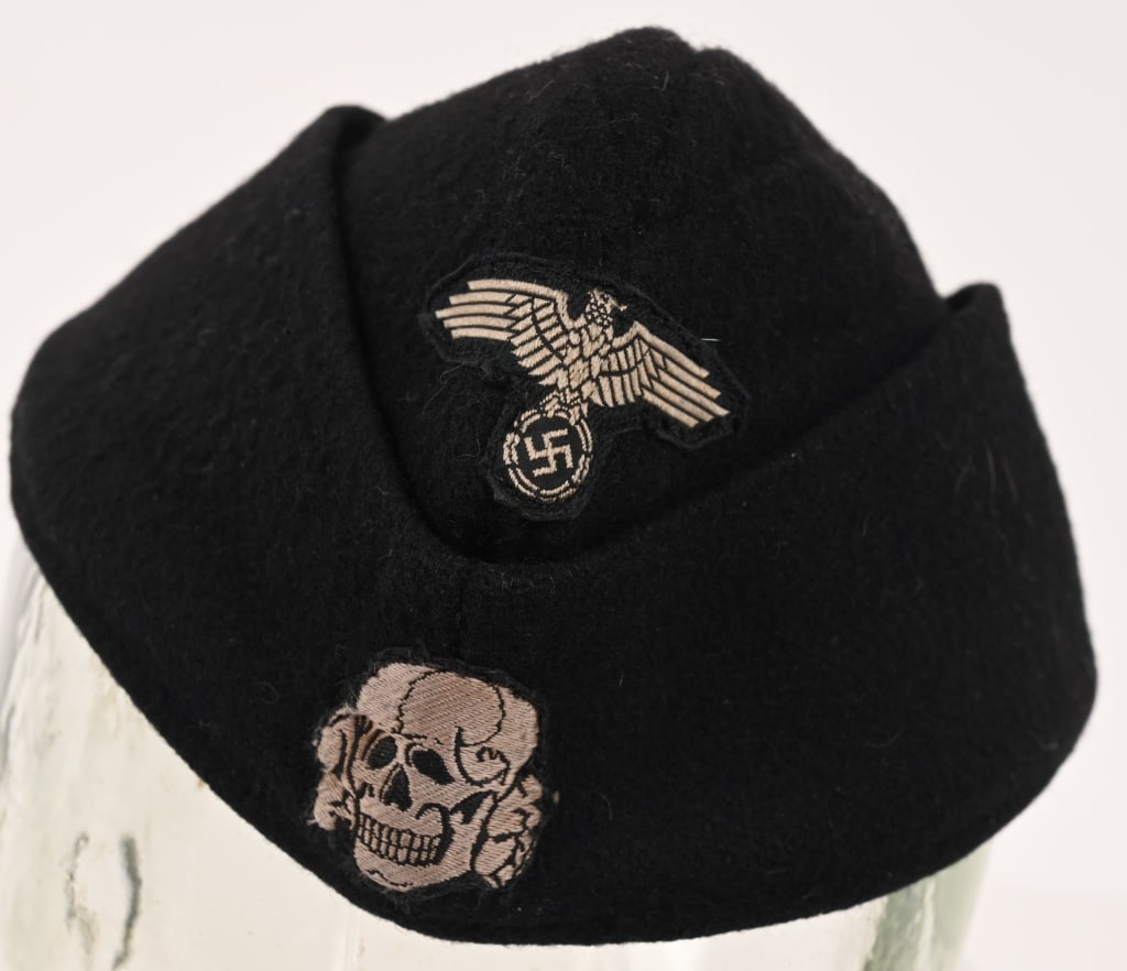 WWII NAZI GERMAN WAFFEN SS PANZER M40 OVERSEAS CAP: Private purchase black wool/rayon blend construction M40 overseas cap with fold down side and back panels that slope gently downwards to the front center. The front center of the cap has a second patt