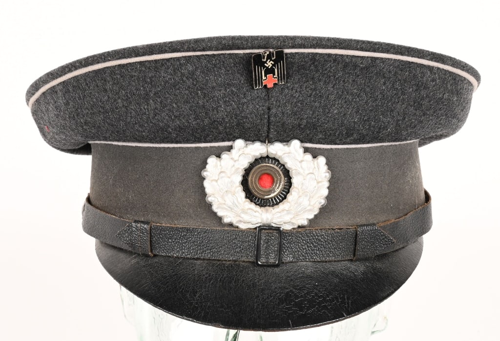 WWII NAZI GERMAN RED CROSS DRK ENLISTED VISOR CAP: Gray wool DRK EM/NCO visor cap whose one-piece circular crown is piped in light gray with a body with seams to each of its cardinal points a one-piece gray center band piped in light gray along both e