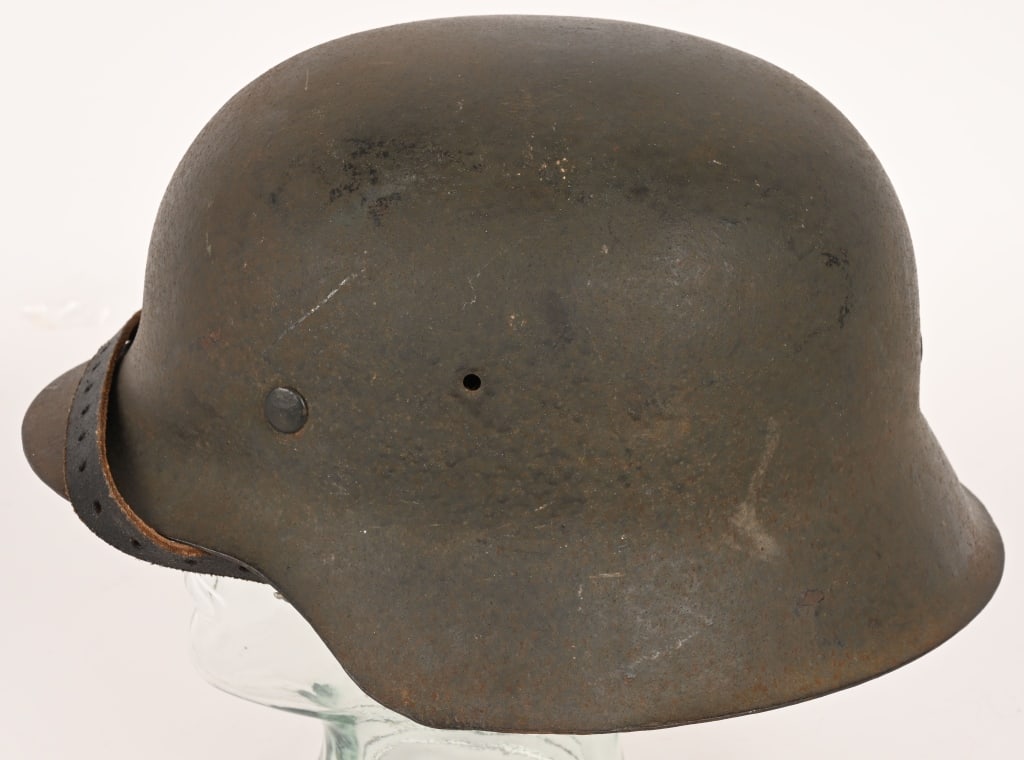 WWII NAZI GERMAN M42 COMBAT HELMET W LINER WW2: The stamped, sheet steel construction helmet retains a good portion of its original field-gray paint. All three liner retaining rivets are all intact. The interior of the helmet has a M31 leather line