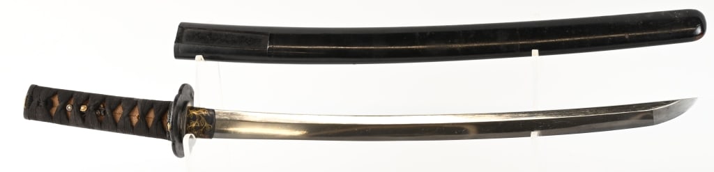 JAPANESE WAKIZASHI WITH ORNATE MOUNTS: 22 1/4" blade with 17 3/8" cutting edge. The blade is bright with a straight hamon and is excellent overall. The one hole tang is not signed. It has a black laquered habaki with gold filigree. The iro