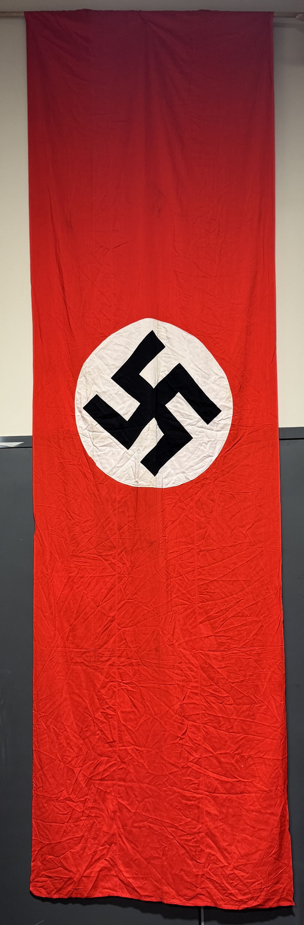 WWII NAZI GERMAN NSDAP FLAG OR BANNER WW2: Roughly 46 X 148 inches and is double sided, cotton construction banner or flag. The flag features a red base field with a separate central white circular disk with a printed canted black swastika to